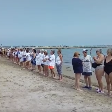 A FALCONARA UNA CATENA UMANA IN SPIAGGIA PER DIRE NO AL MURO DI RFI